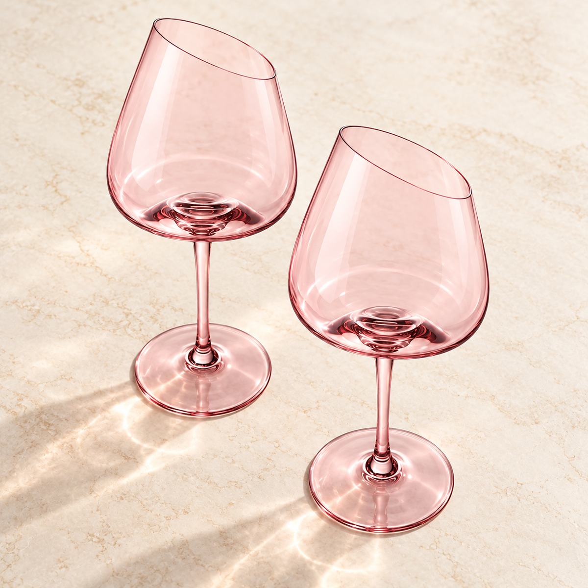 Elevated view of two empty pink slanted-rim wine glasses