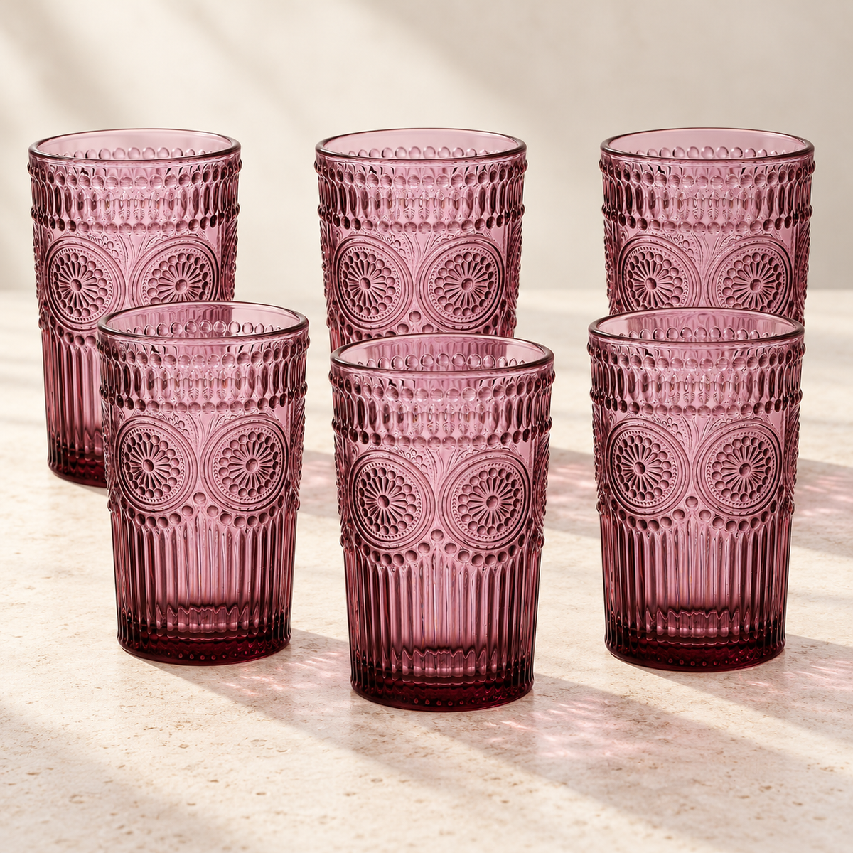 Six purple embossed highball glasses on a neutral stone tabletop
