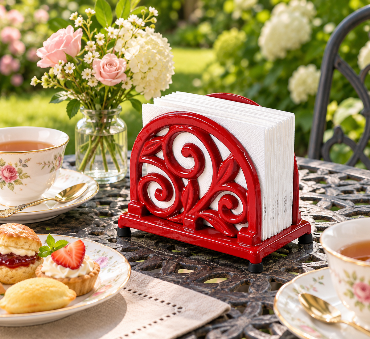 Red scrollwork cast iron napkin holder — garden setting; napkins and props not included