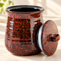 Red and black speckled jar with lid leaning beside it