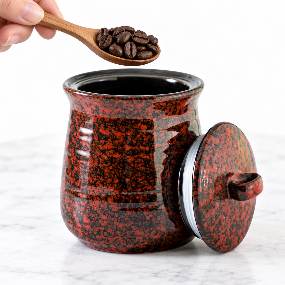 Spoon of coffee beans held above the open jar; styling props not included