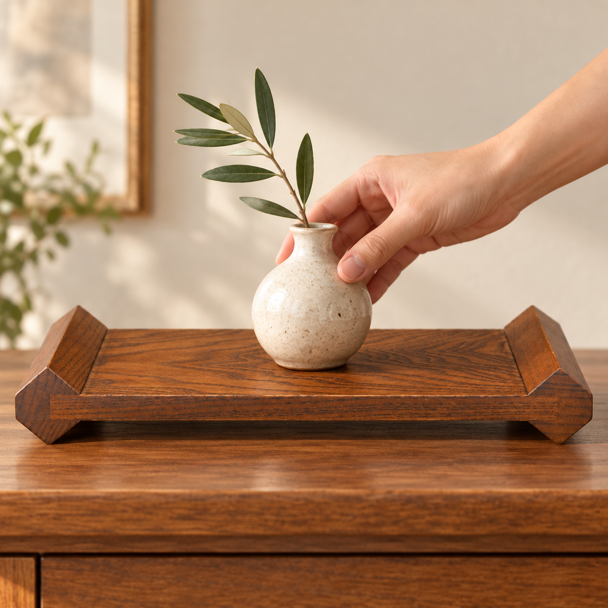 Wooden display riser with a hand placing a small vase, low side view; styling accessories not included