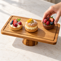 Hand arranging pastries on the acacia pedestal platter
