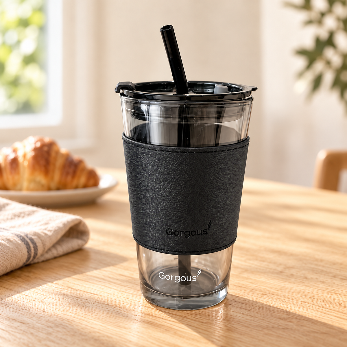 One 450 ml smoky glass cup with neutral black sleeve, black lid and straw on a breakfast table. Food and linens are props.