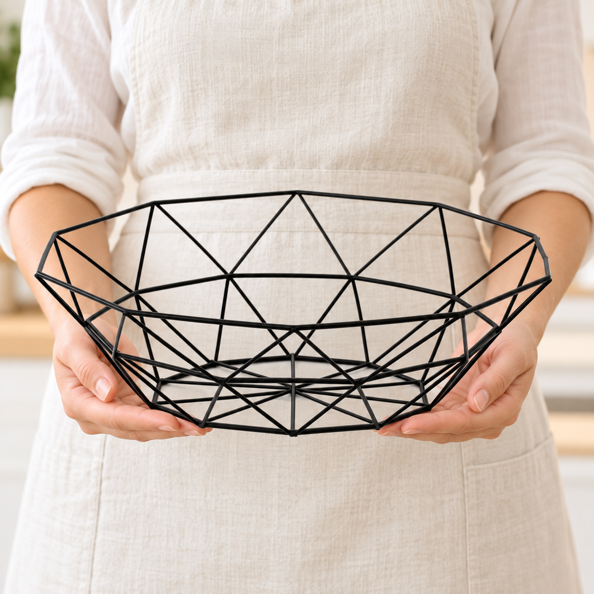 Adult hands holding the empty black wire basket in side profile