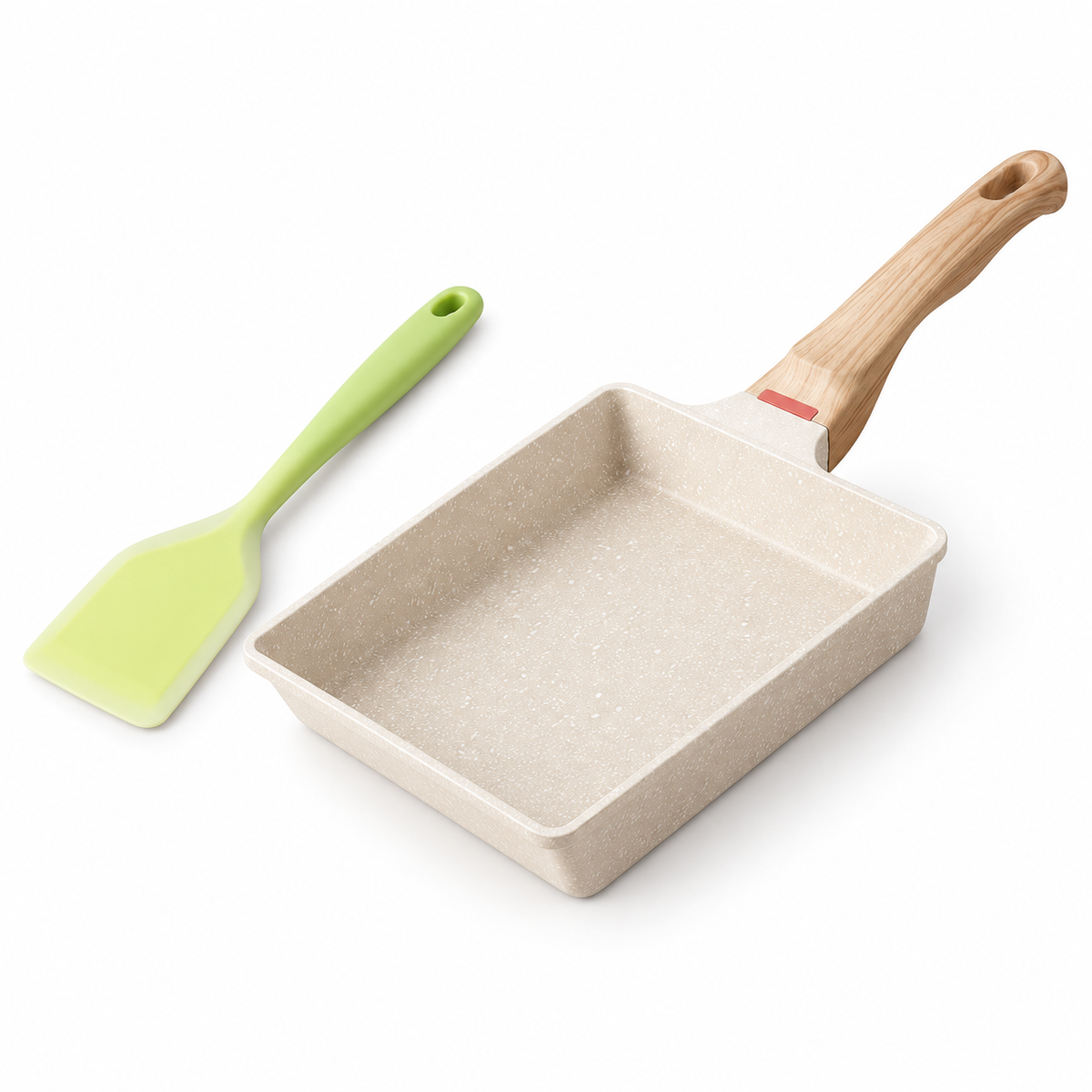 White speckled tamagoyaki pan with wood-look handle and green spatula on white