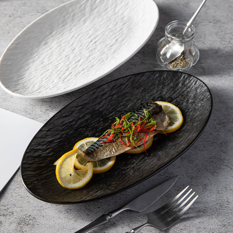 Original supplier photo showing matte black and matte white textured oval serving plates