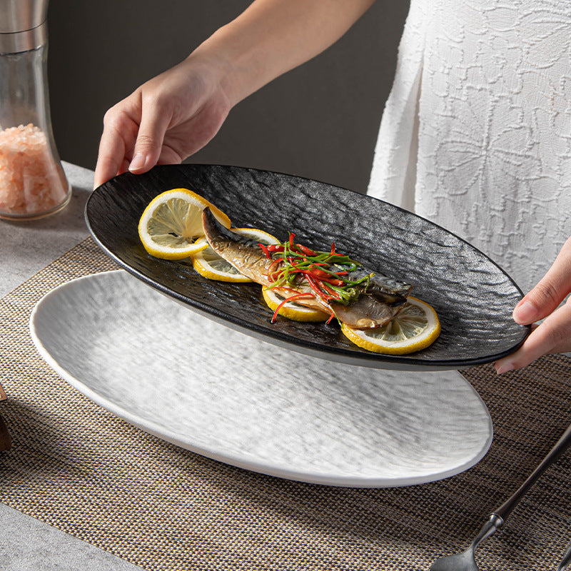 Original supplier serving photo of textured black and white oval plates