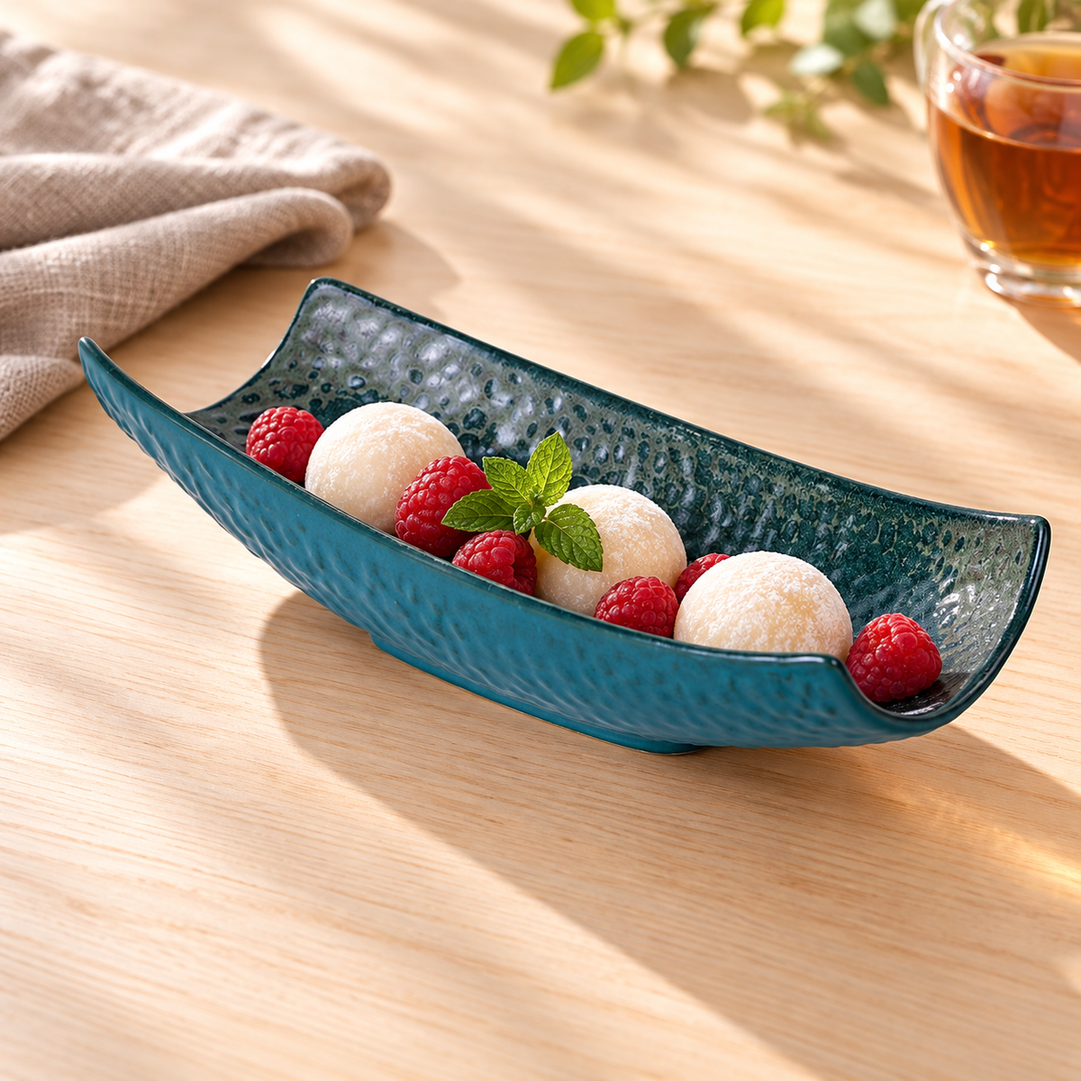 Peacock-green porcelain serving vessel styled with mochi and berries; food and accessories not included