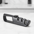 Matte-black multi-stage knife sharpener with comfort-grip handle - clean studio shot on kitchen counter