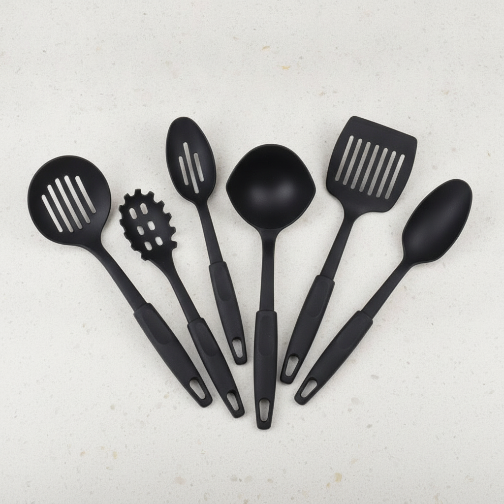 Six-piece black silicone-coated kitchen utensil set fanned out on a light counter