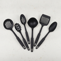Six-piece black silicone-coated kitchen utensil set fanned out on a light counter