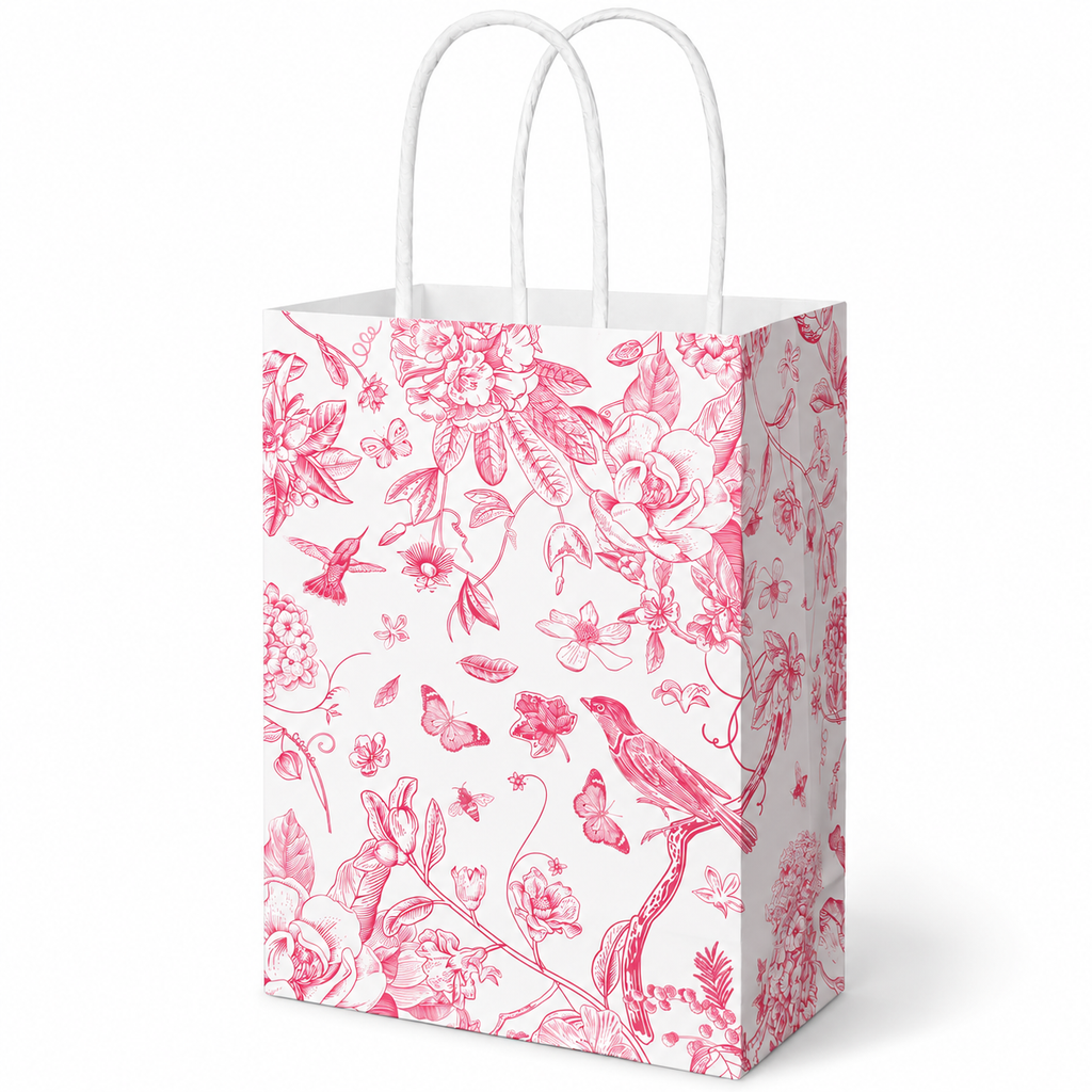 Whaline white gift bag with pink bird and floral print: white studio view; background objects are styling props